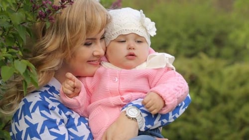 Smiling Mother With Her Baby On Nature