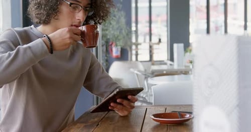 Man having coffee while using tablet