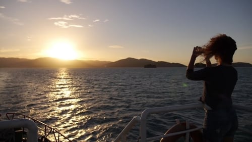 Woman Taking Photos on Boat at Sunset