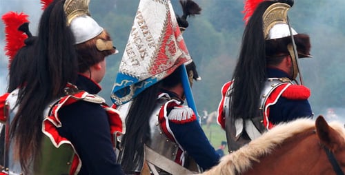 Men Reenacting Historical Battle on Horseback