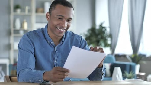 Man Reacting Positively to Documents at Home