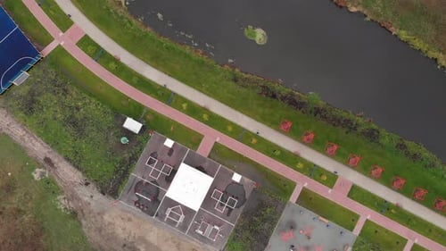 Volleyball, football and boxing areas on green city promenade with small river at autumn