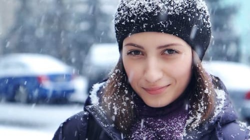 Young Woman in Snowfall with Winter Outfit