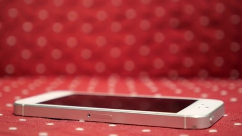 Smartphone Resting on Red Polka Dot Surface
