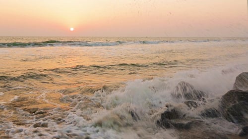 Wellen und Schaum am felsigen Strand