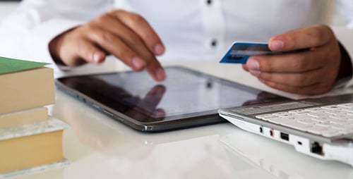 Hands Using Tablet and Credit Card at Desk