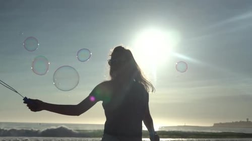 Woman Making Bubbles at Beach During Sunset
