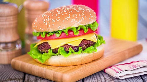 Tasty Cheeseburger on Wooden Cutting Board