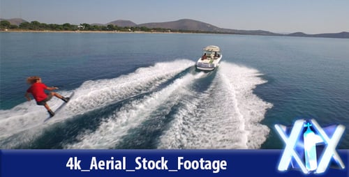 Man Wakeboarding Behind Speedboat on a Sunny Day