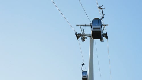 Gondola Ascending on Cables in a City