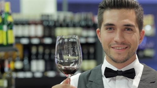 Young Man Smelling and Smiling with Glass of Wine