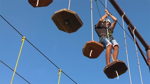 Man Walking on Rope Obstacle Course on Sunny Day