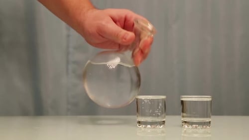 Verser la vodka à la main dans des verres de carafe