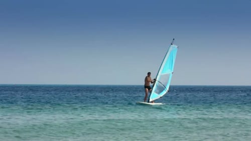 Man Windsurfing on the Ocean on Sunny Day