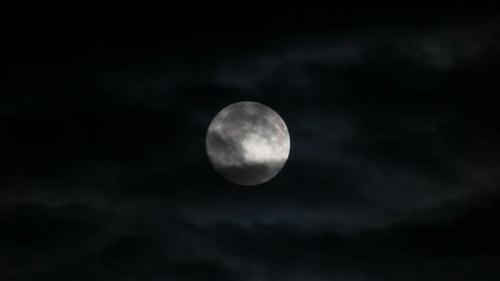 Glowing Moon Behind Clouds in Night Sky