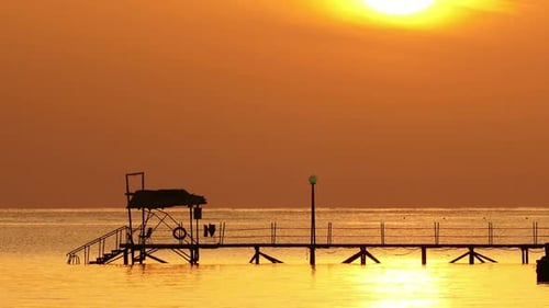 Beautiful Sunrise Over Pier In Sea - Filmed At Telephoto Lens, Zoom Out