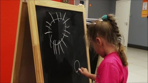 Kleines Mädchen zeichnet Sonnenkreide auf Tafel 2