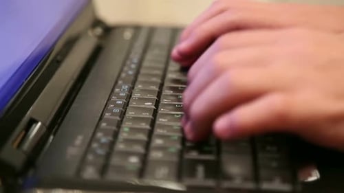 Hands Typing on a Black Laptop Keyboard
