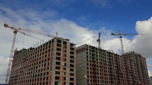 Large Building Under Construction with Cranes on Site
