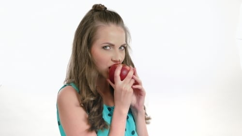 Schönes Mädchen isst einen dunkelroten Apfel - isoliert
