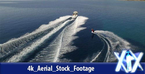 Wakeboarder Riding Behind Boat in Blue Ocean