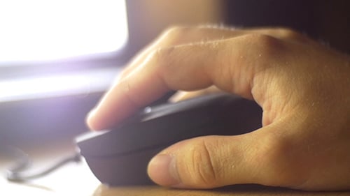 Hand Using Computer Mouse in Office Setting