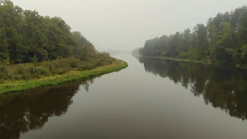 Aerial Landscape of a Misty River Between Jungles of Green Trees Reflected in the Water