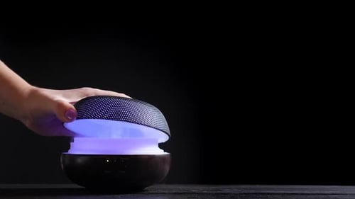 Woman's Hand Adjusting a Glowing Aroma Diffuser
