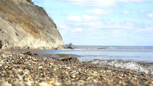 Rocky Beach Shoreline with Gentle Waves and Cliffs