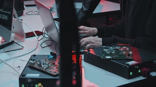 Des hackers méconnaissables codant sur un ordinateur portable