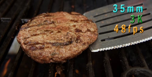 Flipping A Hamburger On The Grill 01