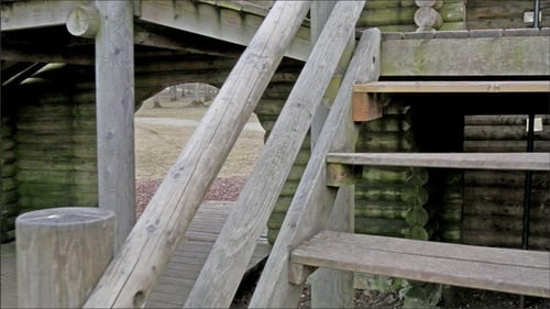 Im Holzspielhaus auf einer Leiter hochgehen