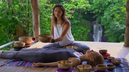 Woman Plays Singing Bowl in Tropical Setting