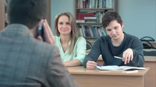 Group of University Students Sitting at Their Desks in Auditorium and Waiting for Teacher, While He
