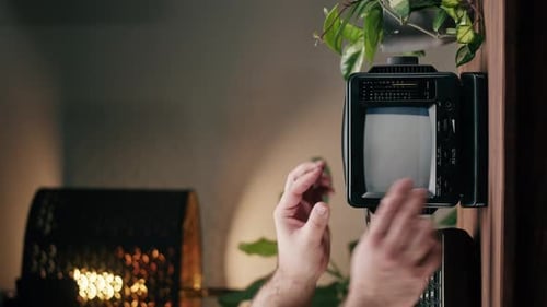 Vídeo vertical de un televisor pequeño y antiguo con pantalla de interferencia gris sobre fondo de inicio