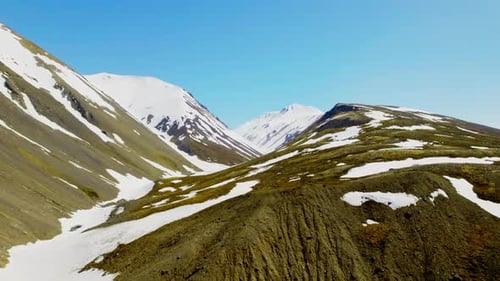 Mountain Top Covered With Patches of Snow and Grass Iceland