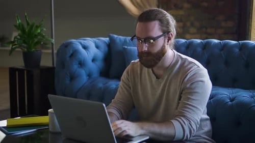 Man Works on Laptop in Urban Apartment