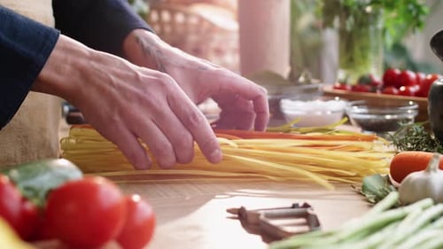Hands of Male Chef Preparing Multicolored Spaghetti for Cooking