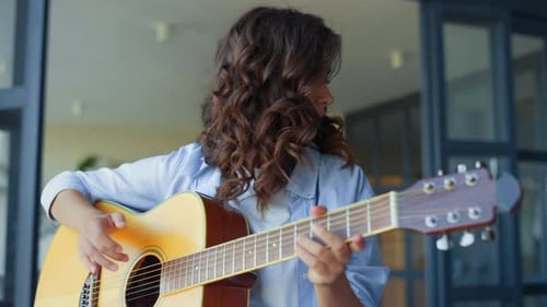Young Woman Playing Acoustic Guitar Indoors