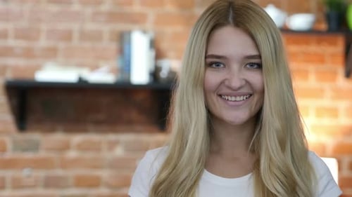 Smiling Woman Looking at Camera in Indoor Setting