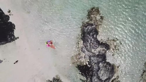 Aerial view of people in summer holiday vacation with beautiful girl on coloured trendy lilo