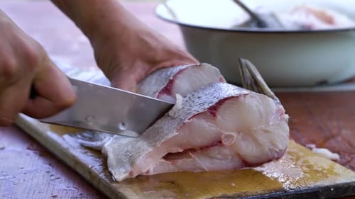 Person Cutting Fresh Fish on Wooden Board