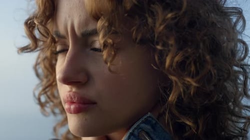 Pensive Woman with Curly Hair Looking Outdoors
