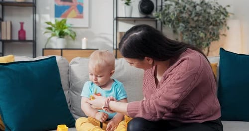 Eine Mutter sitzt mit kleinem Kind auf der Couch