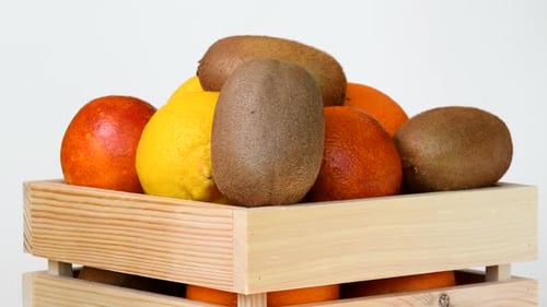 Fruits Rotating in Wooden Box on White Background