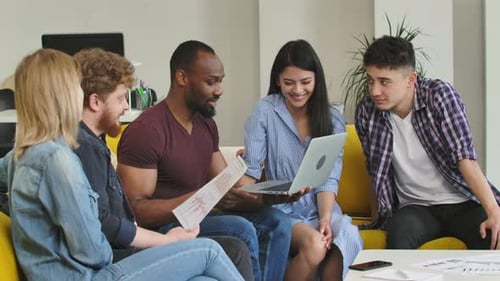 Office Team Collaborating on Computer and Reports