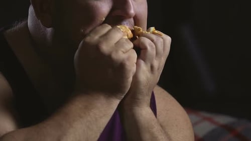 Homme en surpoids malpropre farci avec un hamburger gras, Psychologie de la suralimentation