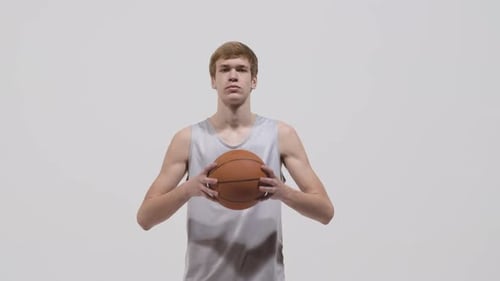 Young Adult Holding a Basketball on White Background
