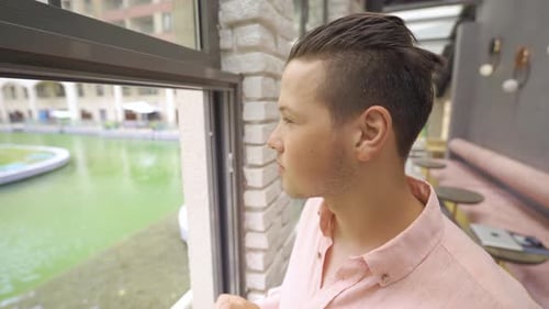 Young Man Looking Out of the Window