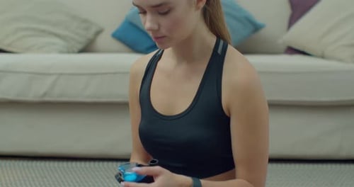 Young Woman Drinks Water After Exercise At Home